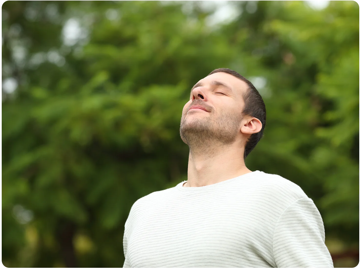 A man breathes in deeply through his nose.