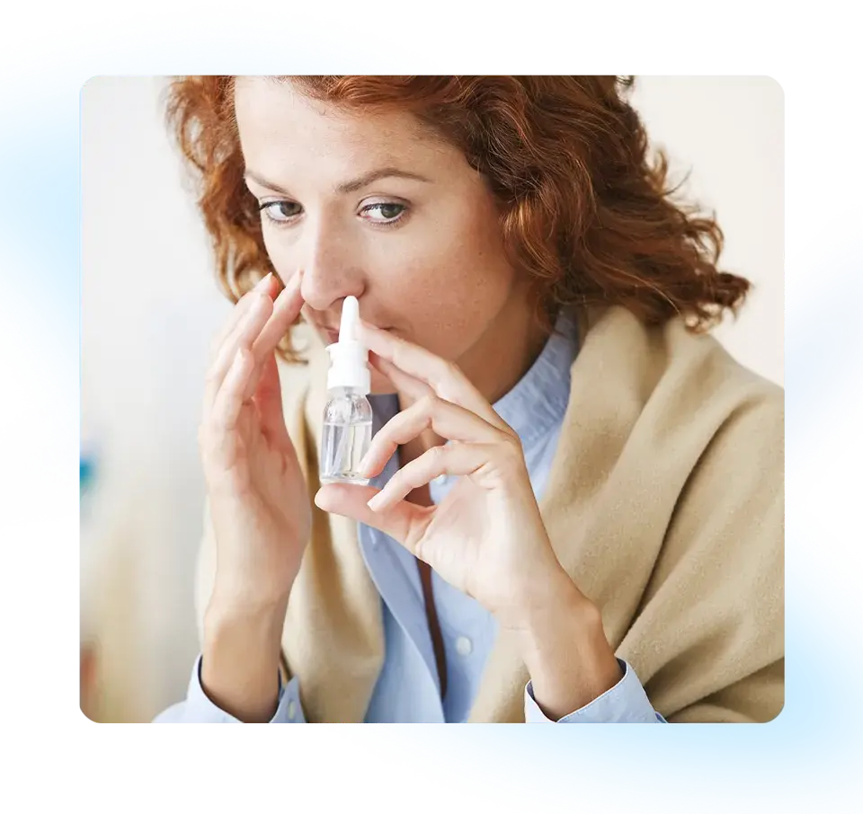 a woman uses a nasal spray