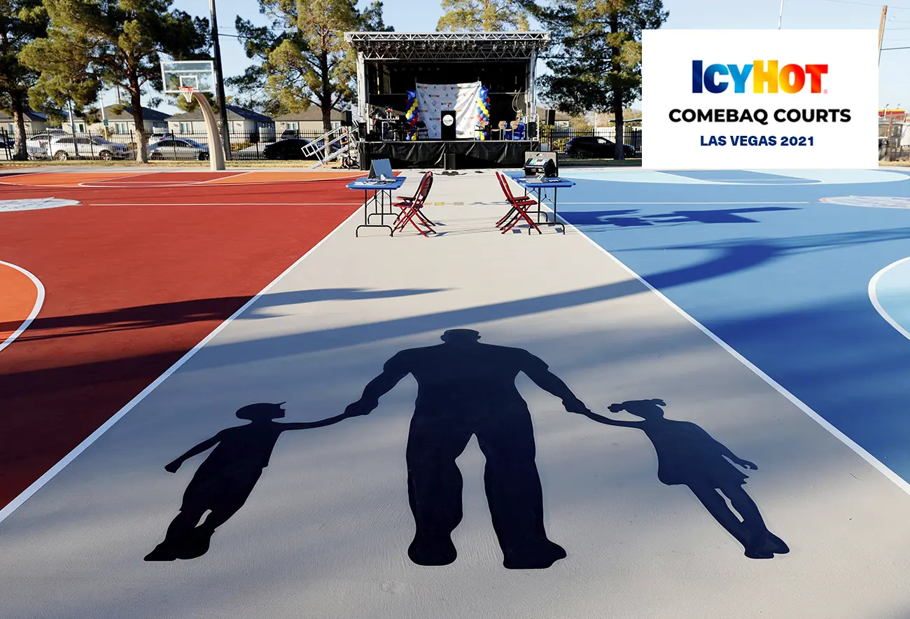 A captivating view of the newly renovated basketball court in Las Vegas, featuring Shaquille O'Neal's foundation's iconic logo beautifully displayed on the floor. The court extends towards the end, leading to an elevated stage proudly showcasing the Icy Hot logo. The upper-right corner of the image features a label displaying the Icy Hot Comebaq Courts logo, along with the event's year (2021) and location (Las Vegas).