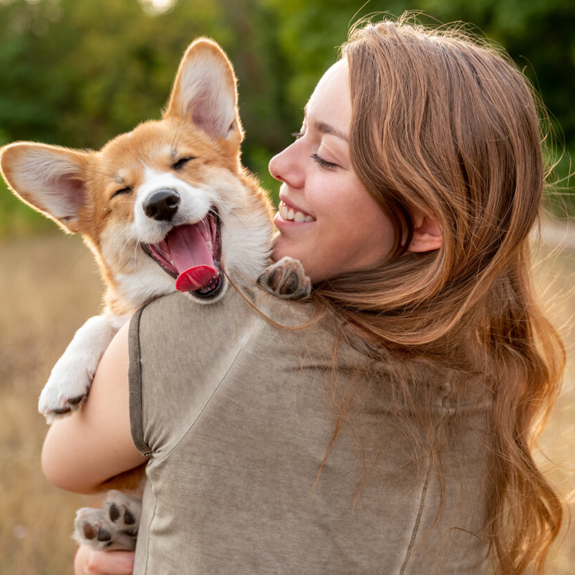Junge Frau trägt ihren glücklichen Hund.