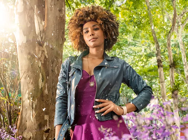 mujer al aire libre de pie junto a un árbol