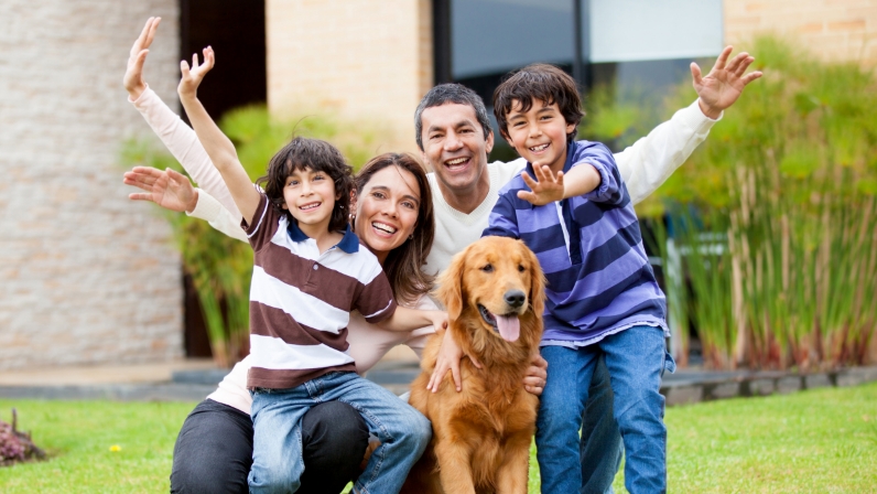 Una familia feliz en su jardín con su perro